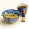 Essiac-Tee mit CBD-Öl zur Entgiftung, dargestellt mit einer Tasse Tee, einer Schale mit Kräuterpulver und einer Flasche CBD-Öl.